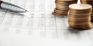 Pen and coins pile on a financial report
