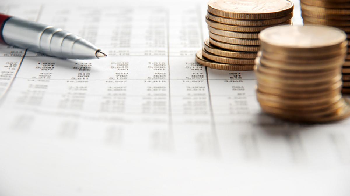 Pen and coins pile on a financial report