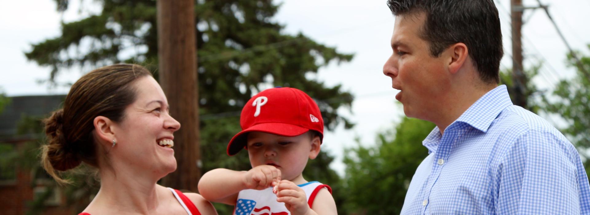 Rep. Boyle talking to a woman with a baby